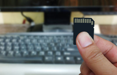 Cropped hand holding memory card