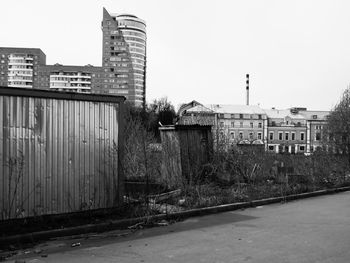 Old buildings by street against sky in city