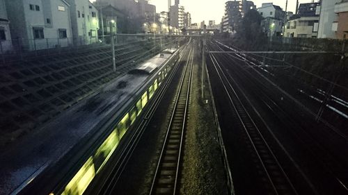 Railroad tracks in city against sky