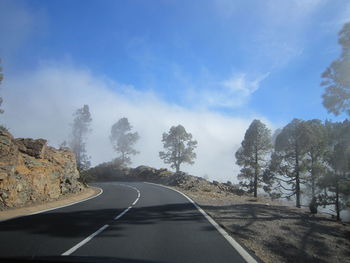 Empty road against cloudy sky