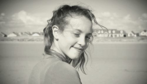 Close-up of girl smiling against sky