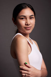 Portrait of young woman against white background