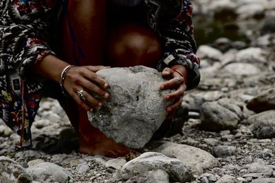 Midsection of woman holding rock