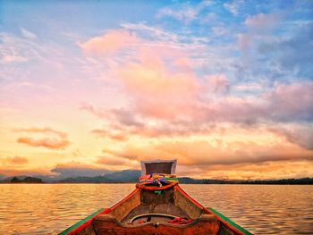 Boat in sea against sky during sunset