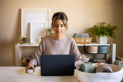 Smiling woman using laptop at home