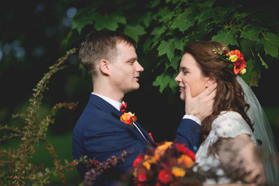 Smiling young couple romancing while standing at park