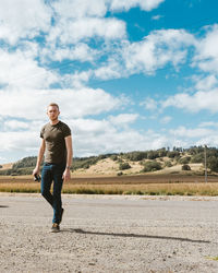 Full length portrait of smiling man standing on land