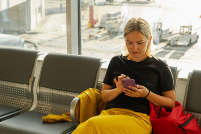 Young woman using mobile phone while sitting in bus