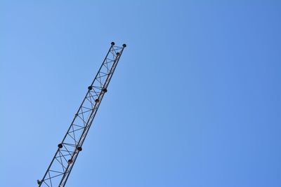 Low angle view of crane against clear blue sky