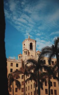 Low angle view of trees and buildings against sky