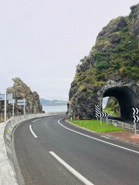 Empty road by mountain against clear sky