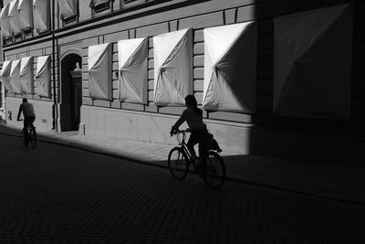 People riding bicycle on street in city
