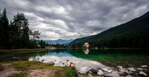 Scenic view of lake by trees against sky