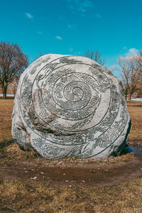 Stone wall on field against sky