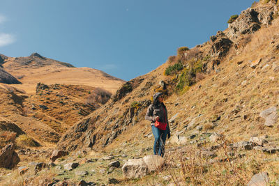 Woman standing on mountain against sky