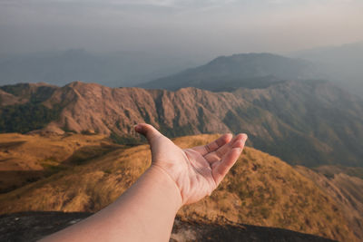 Midsection of person on mountain against sky