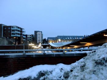 Bridge and buildings against sky during winter