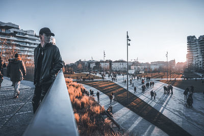 People in city against clear sky during winter