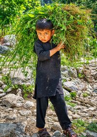 Portrait of boy standing on rock