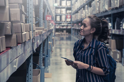 Woman looking at boxes in supermarket