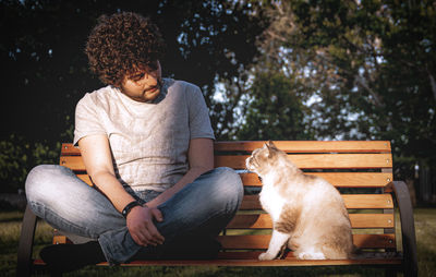 Man with dog sitting on bench