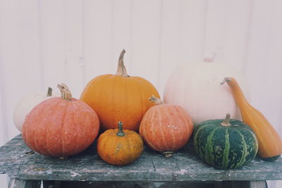 Pumpkins on table against wall