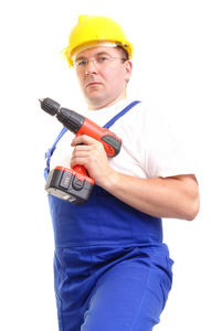 Portrait of man holding hat against white background