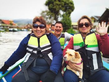 Portrait of smiling people with dog in boat