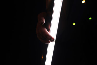 Close-up of hand holding illuminated lighting equipment