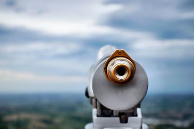 Close-up of coin-operated binoculars against sky