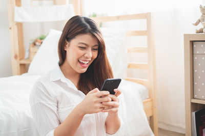 Young woman using mobile phone at home