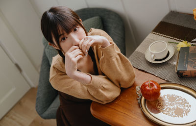 Side view of woman using mobile phone at home