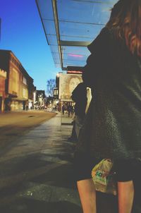 Woman with umbrella against sky in city