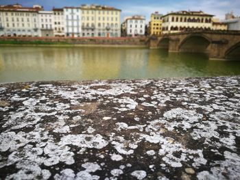 Retaining wall against ponte vecchio over arno river in city
