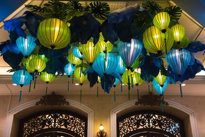 Low angle view of illuminated chandelier hanging on ceiling