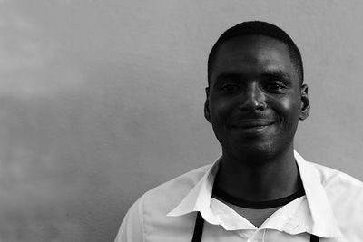 Portrait of young man standing against wall