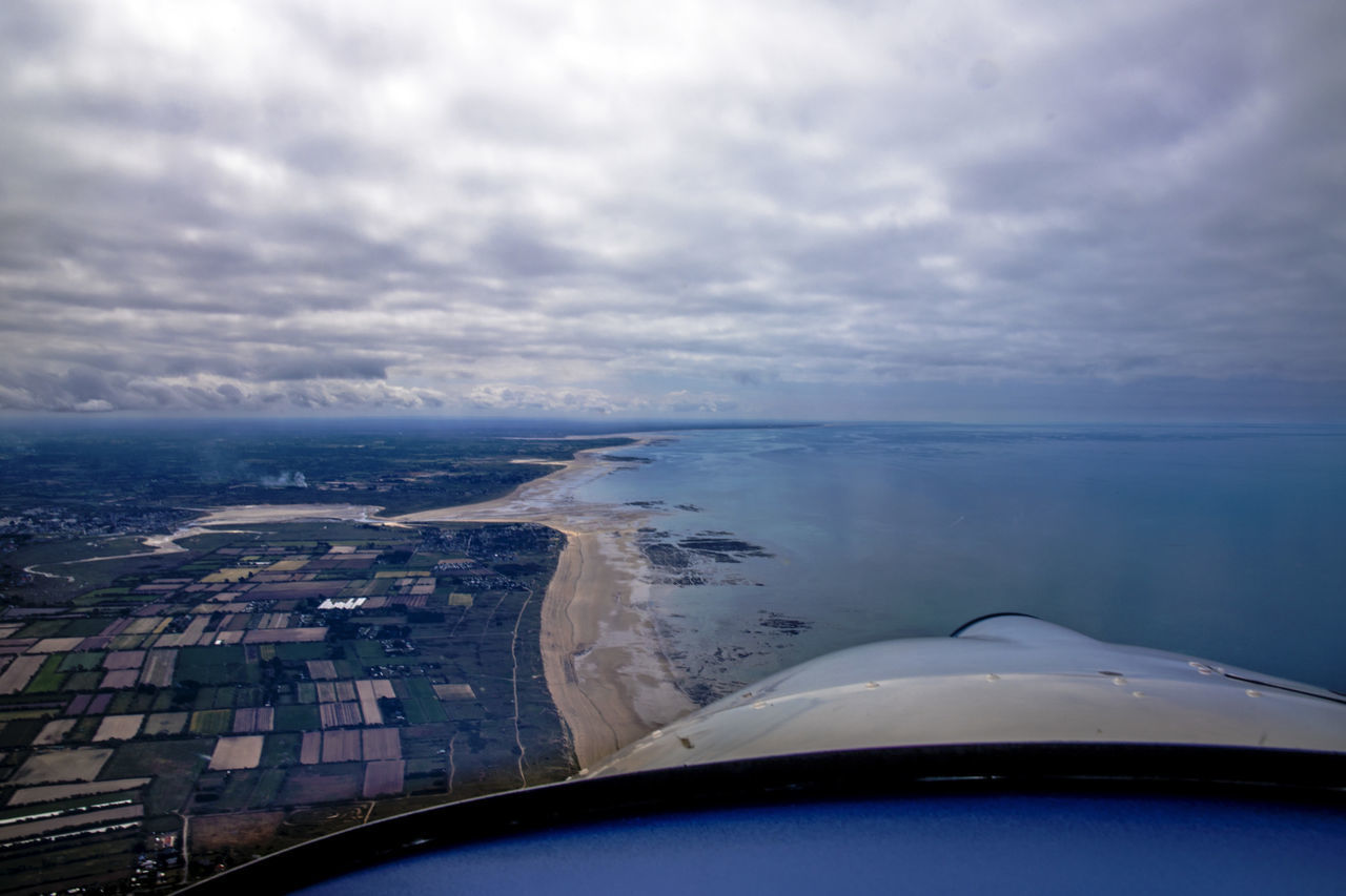 AERIAL VIEW OF SEA AND CITYSCAPE SEEN THROUGH AIRPLANE