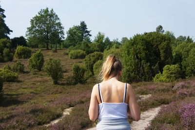 Rear view of woman standing on field