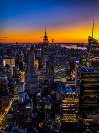 Aerial view of illuminated city buildings during sunset