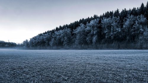 Scenic view of snow covered land against sky