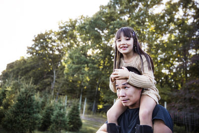 Father carrying daughter on shoulders