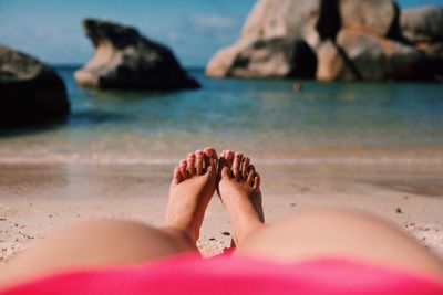 Low section of woman lying at beach