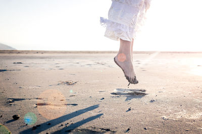 Low section of woman walking on beach