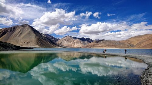 Scenic reflection view of lake and mountains against sky