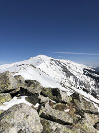 Scenic view of snowcapped mountains against clear blue sky