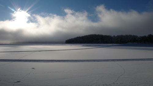 Scenic view of snow covered land against sky