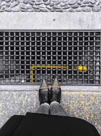 Low section of man standing on cobblestone