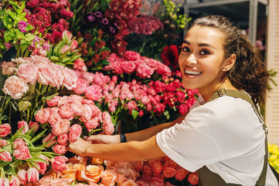 Portrait of smiling florist arranging flowers in shop