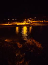 Scenic view of lake against sky at night