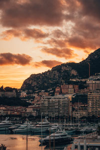 Buildings in town against sky during sunset